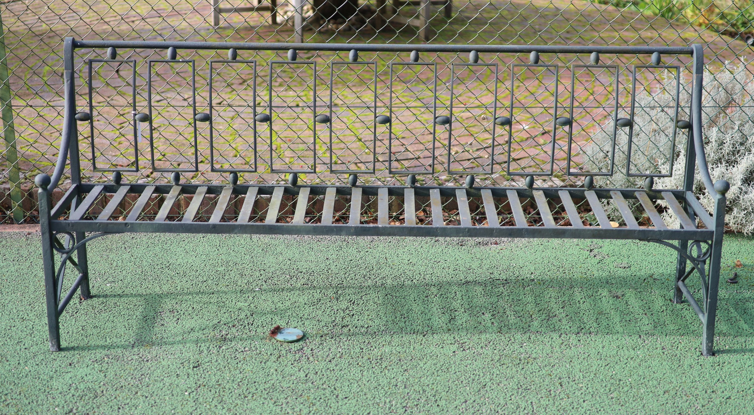 A green painted wrought iron garden bench, W.204cm D.49cm H.87cm
